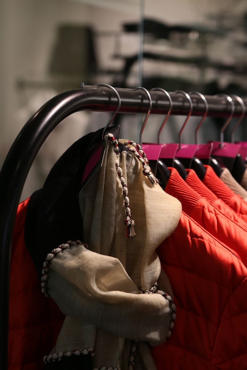 A variety of colorful jackets hanging on a clothes rack in a stylish store.